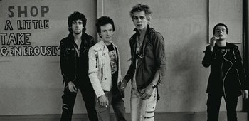 Movie still from “20th Century Women” (2016), directed by Mike Mills – A black and white photo of a group of young men; Medium shot, Low angle