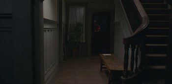 Movie still from “20th Century Women” (2016), directed by Mike Mills – A man standing at the door of a house; Wide shot, Over the shoulder angle