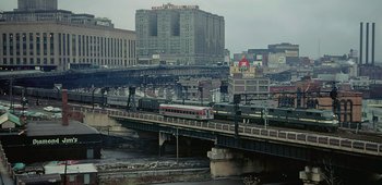 Movie still from “20th Century Women” (2016), directed by Mike Mills – A train on a train track over a bridge; Extreme Wide shot, High angle
