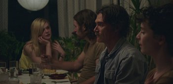 Movie still from “20th Century Women” (2016), directed by Mike Mills – A group of people sitting at a table with plates of food; Medium shot, Over the shoulder angle
