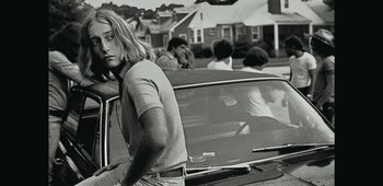 Movie still from “20th Century Women” (2016), directed by Mike Mills – Black and white photograph of a woman in the back seat of a car; Medium shot, Low angle