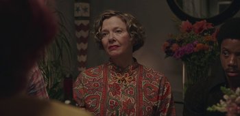 Movie still from “20th Century Women” (2016), directed by Mike Mills – An older woman wearing a colorful shirt looking at the camera; Close Up shot, Over the shoulder angle