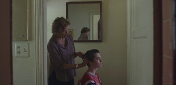 Movie still from “20th Century Women” (2016), directed by Mike Mills – A woman is combing the hair of a young boy; Medium shot, Over the shoulder angle