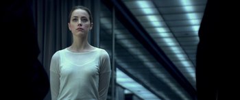 Movie still from “3 Days to Kill” (2014), directed by McG – A woman standing in front of a building; Medium shot, Low angle