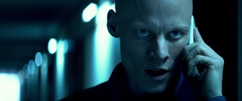 Movie still from “3 Days to Kill” (2014), directed by McG – A man with a bald head is looking into the camera; Close Up shot, Low angle