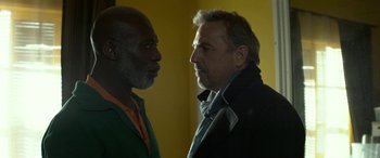 Movie still from “3 Days to Kill” (2014), directed by McG – Two men standing next to each other face to face; Close Up shot, Low angle