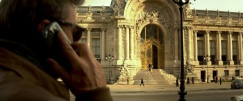 Movie still from “3 Days to Kill” (2014), directed by McG – A person walking on a sidewalk next to a building; Extreme Close Up shot, Low angle