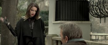 Movie still from “3 Days to Kill” (2014), directed by McG – A man and a woman are standing in front of a building; Medium shot, Over the shoulder angle