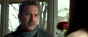 Movie still from “3 Days to Kill” (2014), directed by McG – A person wearing a scarf near a flower; Close Up shot, Over the shoulder angle