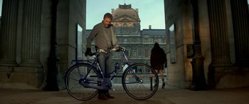 Movie still from “3 Days to Kill” (2014), directed by McG – A man standing next to a blue bicycle; Wide shot, Low angle
