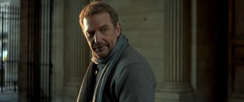 Movie still from “3 Days to Kill” (2014), directed by McG – A person wearing a sweater and a scarf; Close Up shot, Low angle