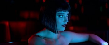 Movie still from “3 Days to Kill” (2014), directed by McG – A woman with short black hair and blue lighting; Close Up shot, Over the shoulder angle