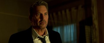 Movie still from “3 Days to Kill” (2014), directed by McG – A person wearing a suit and tie; Close Up shot, Low angle