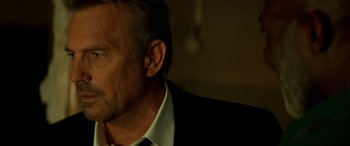 Movie still from “3 Days to Kill” (2014), directed by McG – A person wearing a suit and tie; Close Up shot, Over the shoulder angle
