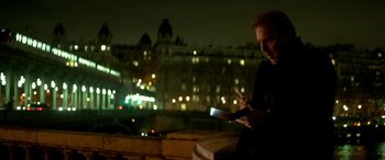 Movie still from “3 Days to Kill” (2014), directed by McG – A man sitting on top of a wooden bench at night; Medium shot, High angle