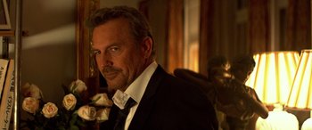 Movie still from “3 Days to Kill” (2014), directed by McG – A person wearing a suit and tie; Close Up shot, Over the shoulder angle