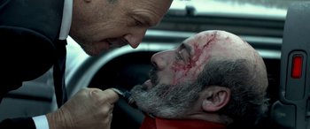 Movie still from “3 Days to Kill” (2014), directed by McG – A man with a beard is getting his face shaved by another man with a beard; Close Up shot, Over the shoulder angle