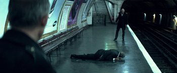 Movie still from “3 Days to Kill” (2014), directed by McG – A man laying on the floor of a train station; Wide shot, High angle