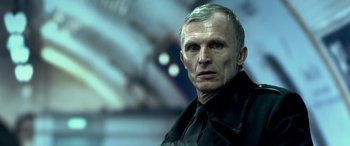 Movie still from “3 Days to Kill” (2014), directed by McG – A person wearing a black shirt and tie; Close Up shot, Low angle