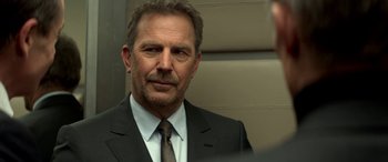 Movie still from “3 Days to Kill” (2014), directed by McG – A person wearing a suit and tie; Close Up shot, Over the shoulder angle