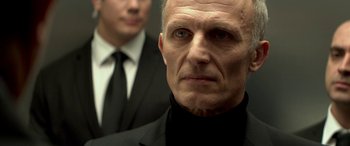 Movie still from “3 Days to Kill” (2014), directed by McG – A person wearing a suit and tie; Close Up shot, Over the shoulder angle