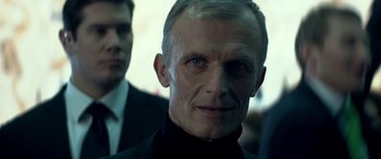 Movie still from “3 Days to Kill” (2014), directed by McG – A person wearing a suit and tie; Close Up shot, Low angle