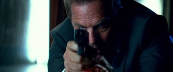 Movie still from “3 Days to Kill” (2014), directed by McG – A person holding a gun; Close Up shot, Low angle