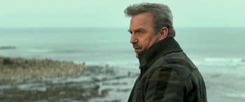 Movie still from “3 Days to Kill” (2014), directed by McG – A person standing near a body of water; Close Up shot, Over the shoulder angle