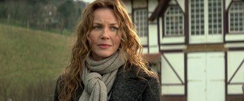 Movie still from “3 Days to Kill” (2014), directed by McG – A person with long hair wearing a scarf; Close Up shot, Over the shoulder angle