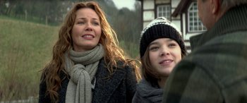 Movie still from “3 Days to Kill” (2014), directed by McG – A woman and a girl standing next to each other; Close Up shot, Over the shoulder angle
