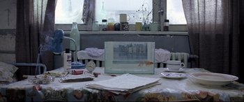Movie still from “4 Months, 3 Weeks and 2 Days” (2007), directed by Cristian Mungiu – A table that has papers on top of it; Medium shot, High angle