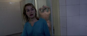 Movie still from “4 Months, 3 Weeks and 2 Days” (2007), directed by Cristian Mungiu – A woman standing in front of a bathroom mirror; Medium shot, Over the shoulder angle