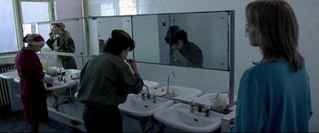 Movie still from “4 Months, 3 Weeks and 2 Days” (2007), directed by Cristian Mungiu – A woman is standing in front of a bathroom mirror; Medium shot, High angle