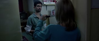 Movie still from “4 Months, 3 Weeks and 2 Days” (2007), directed by Cristian Mungiu – A man is looking at a woman in the mirror; Medium shot, Over the shoulder angle