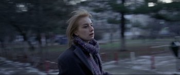 Movie still from “4 Months, 3 Weeks and 2 Days” (2007), directed by Cristian Mungiu – A young woman in a black coat and a scarf; Close Up shot, Low angle