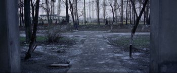 Movie still from “4 Months, 3 Weeks and 2 Days” (2007), directed by Cristian Mungiu – An empty road in the middle of a forest; Extreme Wide shot, High angle