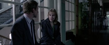 Movie still from “4 Months, 3 Weeks and 2 Days” (2007), directed by Cristian Mungiu – A woman and a man sitting in front of a window; Medium shot, Over the shoulder angle