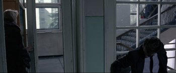 Movie still from “4 Months, 3 Weeks and 2 Days” (2007), directed by Cristian Mungiu – A cat sitting on the floor in a room; Medium shot, Over the shoulder angle