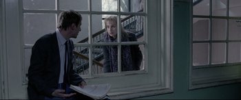 Movie still from “4 Months, 3 Weeks and 2 Days” (2007), directed by Cristian Mungiu – A man and a woman looking out of a window; Medium shot, Over the shoulder angle