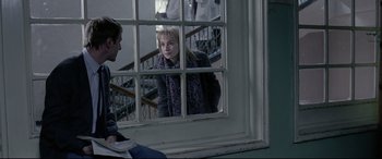 Movie still from “4 Months, 3 Weeks and 2 Days” (2007), directed by Cristian Mungiu – A woman looking out of a window at a man; Medium shot, Over the shoulder angle