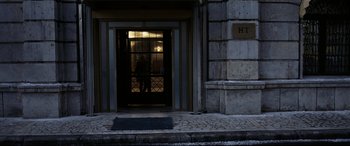 Movie still from “4 Months, 3 Weeks and 2 Days” (2007), directed by Cristian Mungiu – A person standing in front of a building at night; Wide shot, Low angle