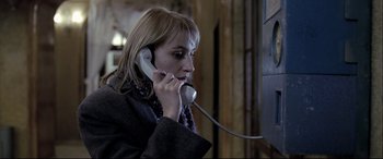 Movie still from “4 Months, 3 Weeks and 2 Days” (2007), directed by Cristian Mungiu – A woman talking on a phone while wearing a scarf; Close Up shot, Low angle