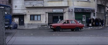 Movie still from “4 Months, 3 Weeks and 2 Days” (2007), directed by Cristian Mungiu – A red car parked on the side of the street; Wide shot, High angle