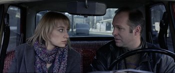 Movie still from “4 Months, 3 Weeks and 2 Days” (2007), directed by Cristian Mungiu – A man and a woman sitting in the back of a car; Close Up shot, Over the shoulder angle
