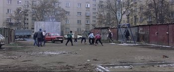 Movie still from “4 Months, 3 Weeks and 2 Days” (2007), directed by Cristian Mungiu – A group of young men playing a game of baseball; Wide shot, High angle