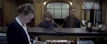 Movie still from “4 Months, 3 Weeks and 2 Days” (2007), directed by Cristian Mungiu – A woman sitting at a counter in front of a man; Medium shot, Low angle