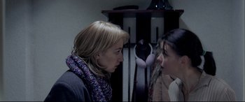 Movie still from “4 Months, 3 Weeks and 2 Days” (2007), directed by Cristian Mungiu – Two women talking to each other in front of a wall; Close Up shot, Over the shoulder angle
