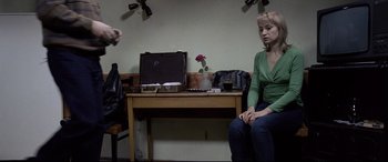 Movie still from “4 Months, 3 Weeks and 2 Days” (2007), directed by Cristian Mungiu – A woman sitting at a desk in front of a laptop computer; Medium shot, Over the shoulder angle