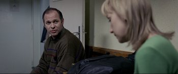 Movie still from “4 Months, 3 Weeks and 2 Days” (2007), directed by Cristian Mungiu – A man sitting in front of a mirror looking at a woman; Medium shot, Over the shoulder angle