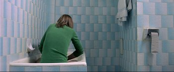 Movie still from “4 Months, 3 Weeks and 2 Days” (2007), directed by Cristian Mungiu – A person sitting in a bath tub in front of a tiled wall; Medium shot, Overhead angle